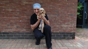 Toy poodle Monty being held by Noel Fitzpatrick